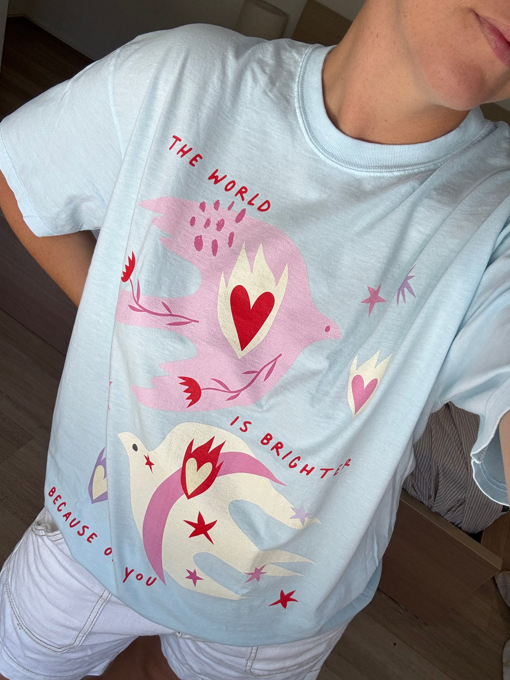 Person wearing a light blue tank top with colorful animal illustrations and text.