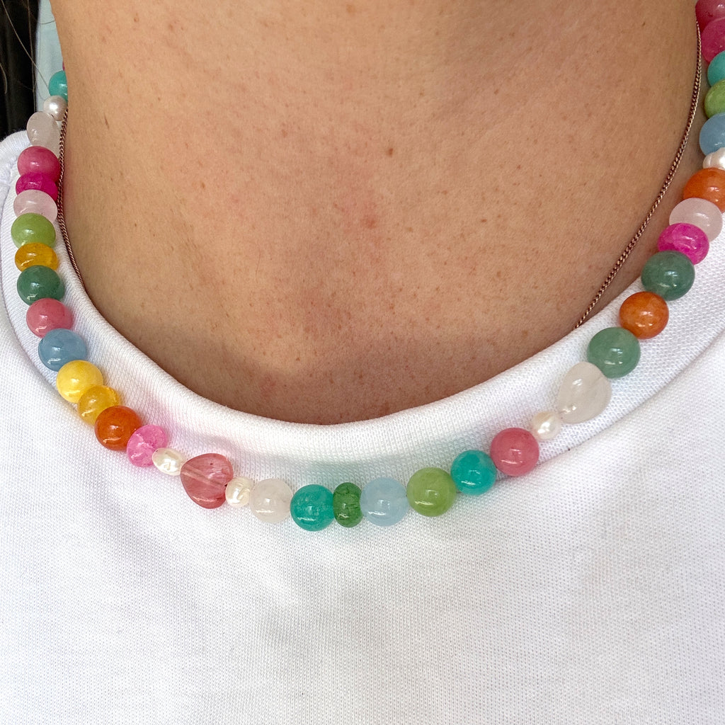 Colorful beaded bracelet on a person's wrist against a white background